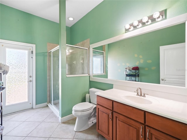 bathroom with toilet, a wealth of natural light, tile floors, and vanity with extensive cabinet space