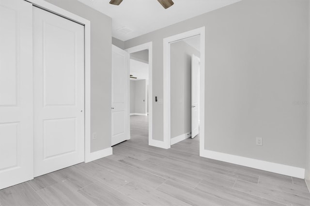 unfurnished bedroom with a closet, ceiling fan, and light wood-type flooring