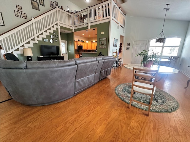 living room featuring light hardwood / wood-style floors and a high ceiling