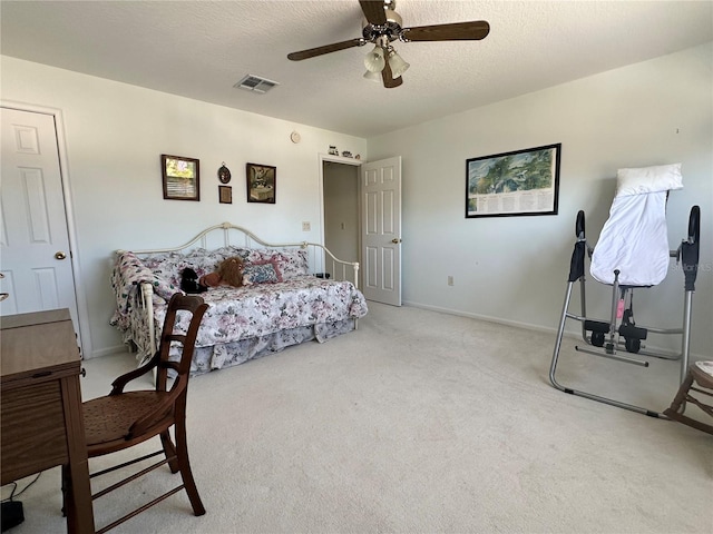 carpeted bedroom with ceiling fan and a textured ceiling