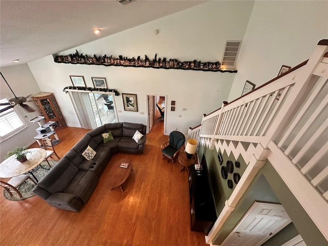 living room with high vaulted ceiling and hardwood / wood-style floors