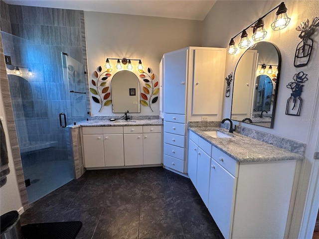 bathroom with a shower with door, dual bowl vanity, and tile flooring