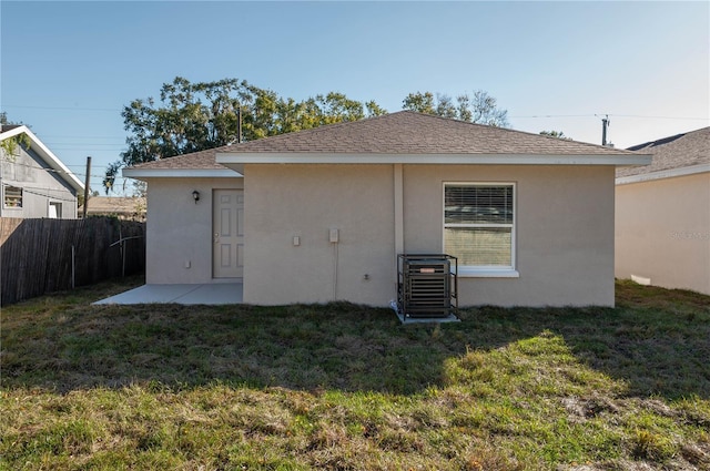 back of house with a yard and central air condition unit