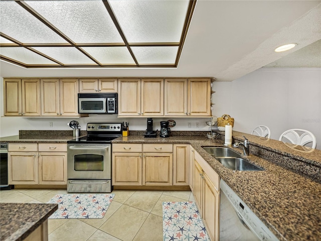 kitchen with light tile flooring, light brown cabinetry, appliances with stainless steel finishes, sink, and dark stone counters