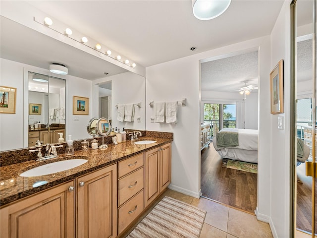 bathroom with vanity with extensive cabinet space, double sink, tile flooring, and ceiling fan