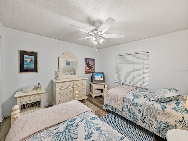 bedroom with a textured ceiling, ceiling fan, and dark wood-type flooring