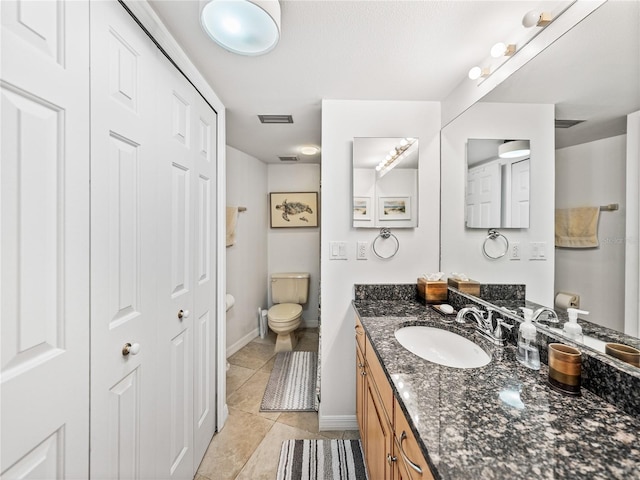 bathroom with large vanity, tile floors, and toilet