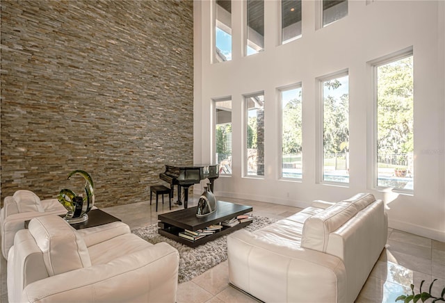 living room with plenty of natural light, a high ceiling, and tile floors