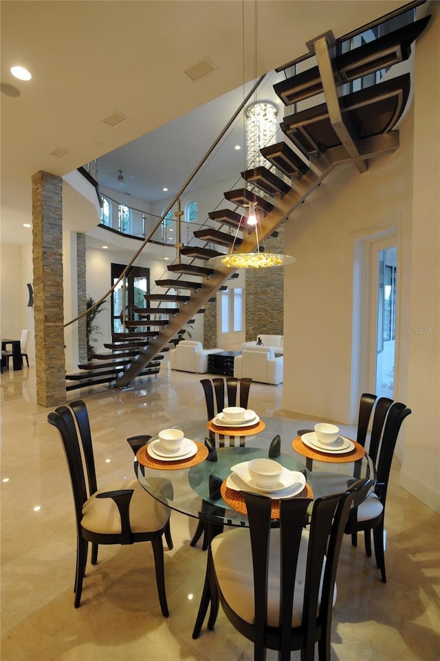 dining space with light tile floors and a high ceiling