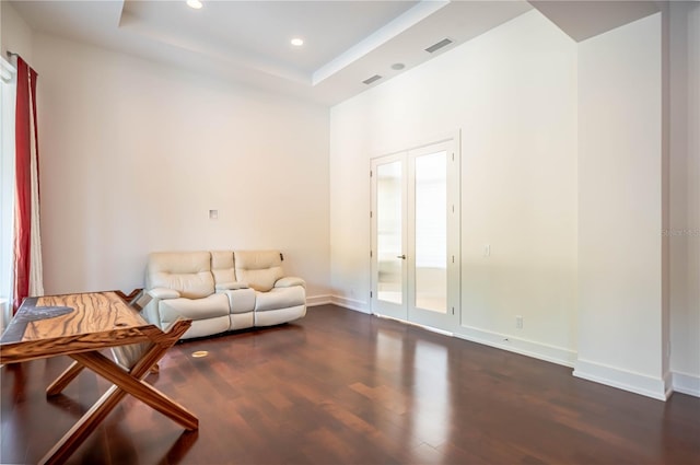 living area featuring dark hardwood / wood-style flooring, french doors, and a tray ceiling