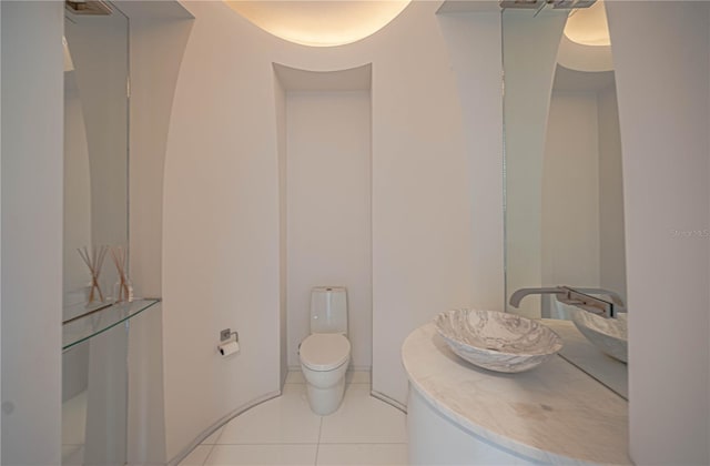 bathroom featuring tile floors, vanity, and toilet