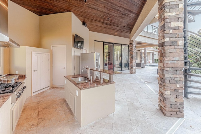 kitchen featuring fume extractor, light stone countertops, appliances with stainless steel finishes, wooden ceiling, and sink