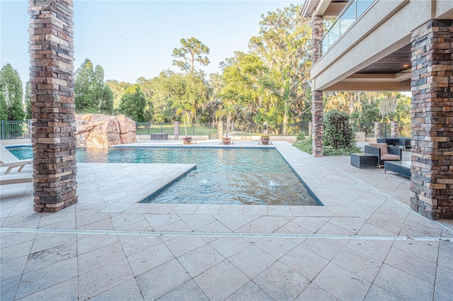 view of pool with a patio and pool water feature