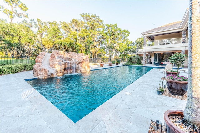 view of swimming pool with pool water feature, a patio, and a water slide