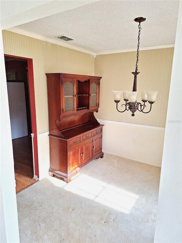 unfurnished room featuring hardwood / wood-style floors, a notable chandelier, crown molding, and a textured ceiling