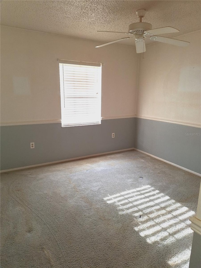 carpeted spare room with a textured ceiling and ceiling fan