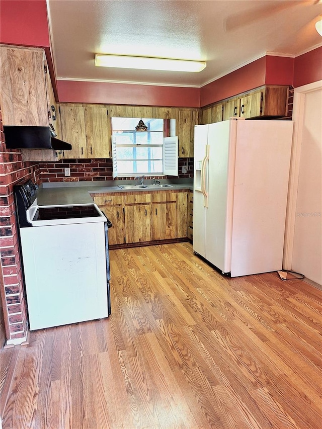 kitchen with white appliances, sink, and light wood-type flooring