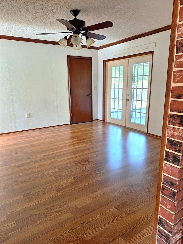 spare room with french doors, ceiling fan, dark hardwood / wood-style floors, and a textured ceiling