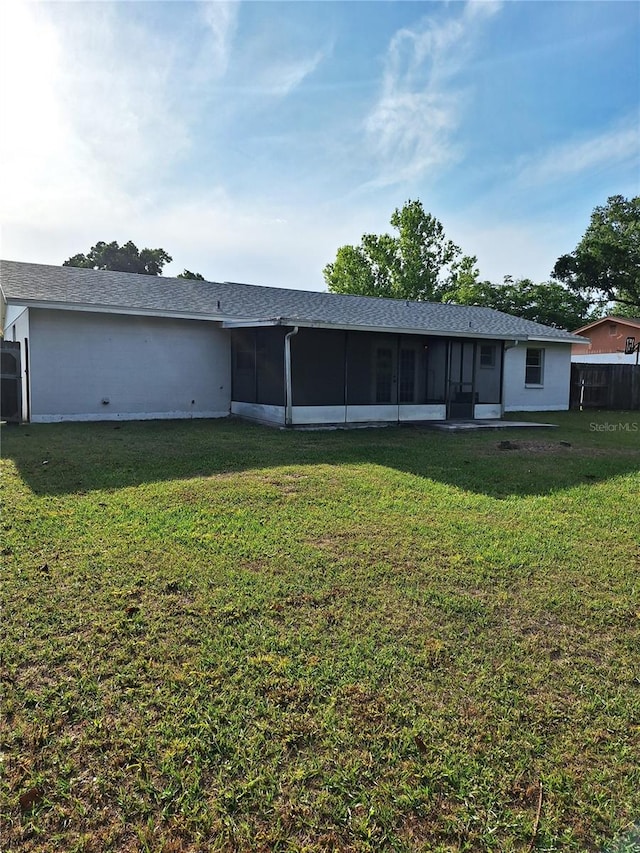 rear view of property with a yard and a sunroom