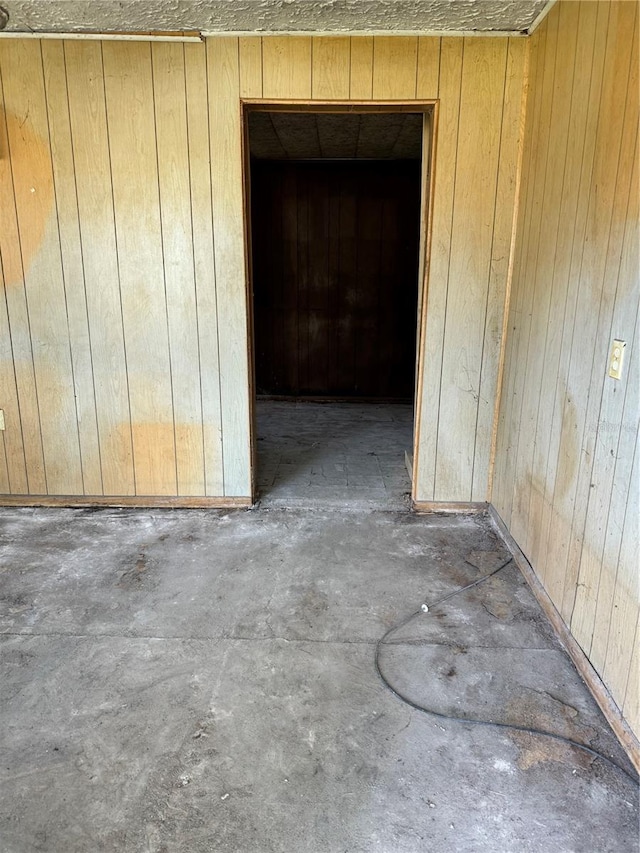 unfurnished room featuring wooden walls