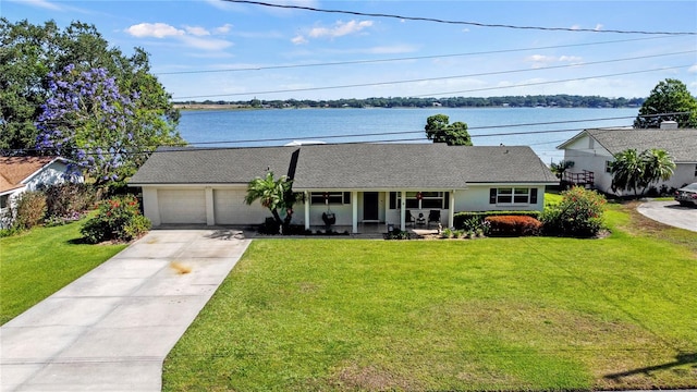 single story home with a water view, a front lawn, and a garage