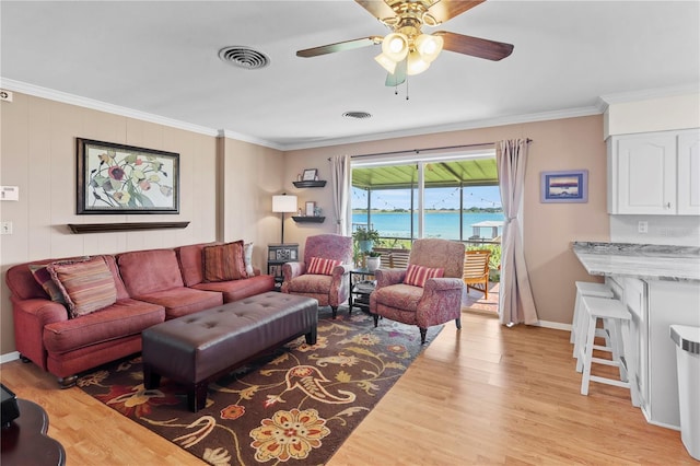 living room with light hardwood / wood-style flooring, a water view, ceiling fan, and crown molding