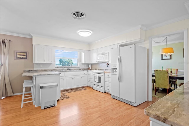 kitchen with white appliances, white cabinetry, sink, a kitchen bar, and light hardwood / wood-style floors