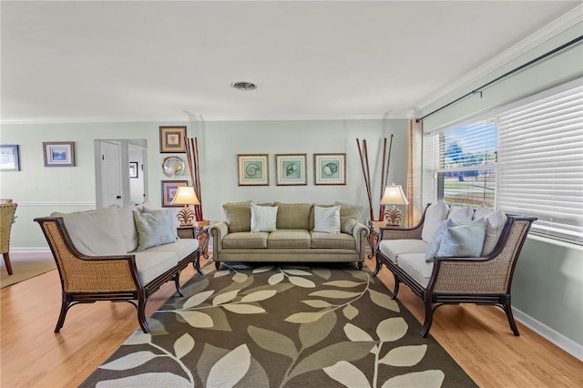 living room with wood-type flooring and ornamental molding