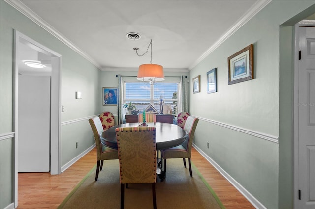 dining room featuring hardwood / wood-style flooring and ornamental molding