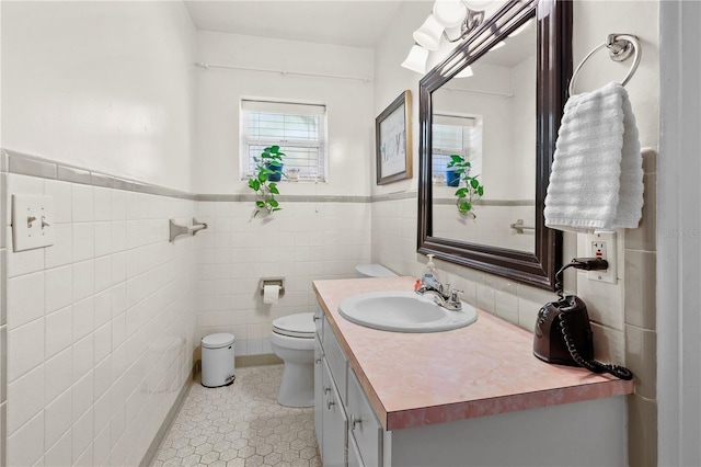 bathroom featuring toilet, tile flooring, tile walls, and large vanity