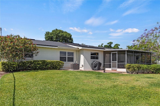 rear view of property featuring central AC, a yard, and a sunroom