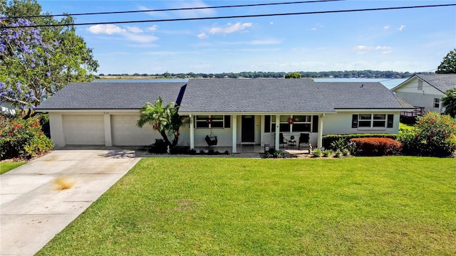 ranch-style home featuring a porch, a garage, and a front yard