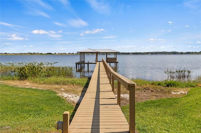 view of dock featuring a water view and a lawn