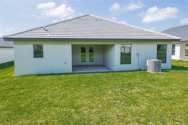 back of house with a patio area, french doors, a lawn, and central AC