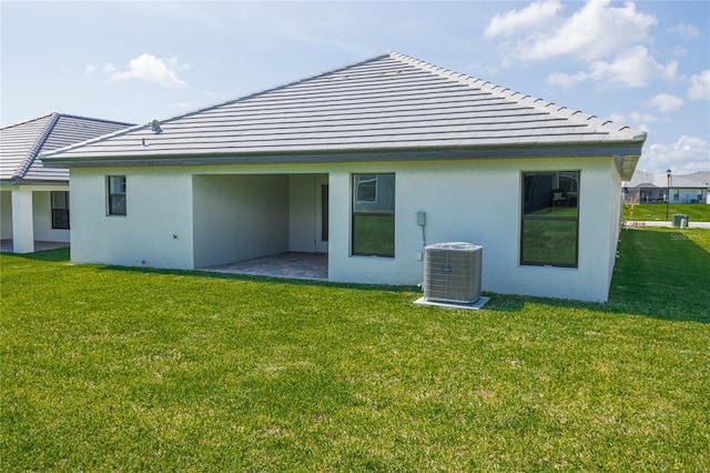 back of house featuring a yard, central AC, and a patio area