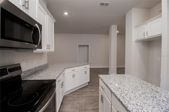 kitchen featuring light stone counters, appliances with stainless steel finishes, and white cabinets