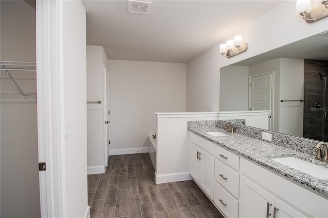 bathroom with double vanity and hardwood / wood-style floors