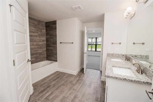 bathroom featuring dual vanity and tiled shower / bath combo