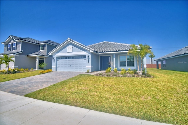 view of front of house featuring a tile roof, decorative driveway, a garage, and a front lawn
