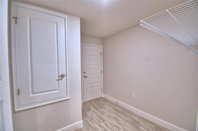interior space with baseboards and light wood-type flooring