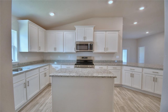kitchen featuring white cabinetry, light wood-style flooring, a kitchen island, and stainless steel appliances