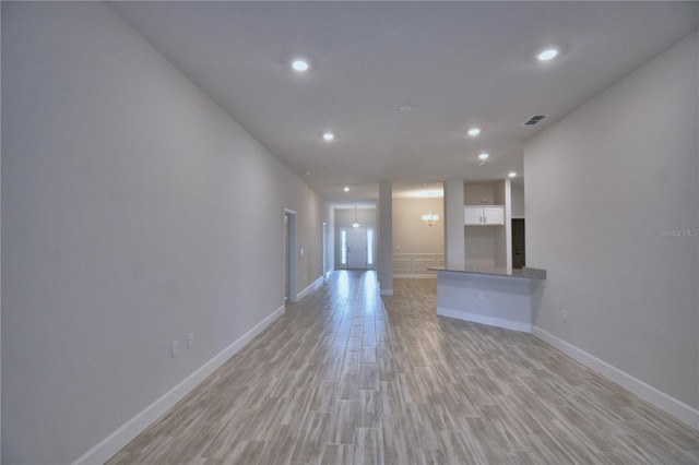 unfurnished living room featuring baseboards, light wood-style floors, and recessed lighting