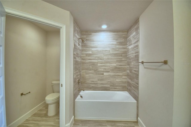 bathroom with baseboards,  shower combination, toilet, and wood finished floors