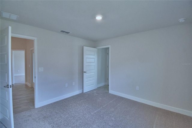 unfurnished bedroom with baseboards, carpet flooring, and visible vents