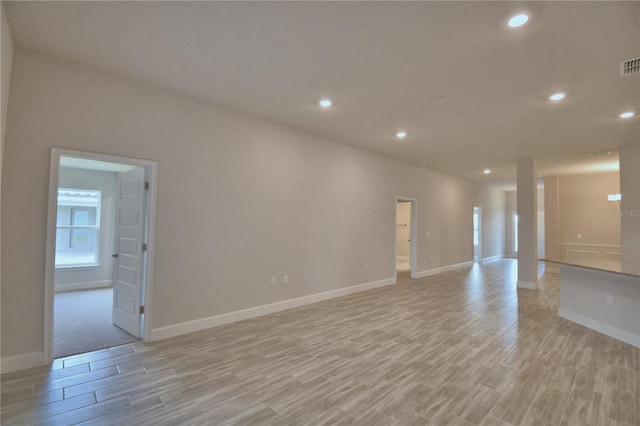 empty room with light wood finished floors, baseboards, visible vents, and recessed lighting