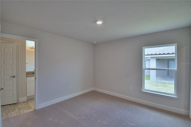 empty room with baseboards and light colored carpet