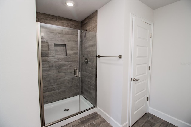 bathroom featuring a shower with shower door and hardwood / wood-style floors