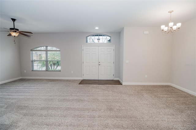 foyer featuring carpet flooring and ceiling fan with notable chandelier