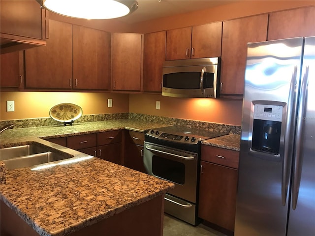 kitchen featuring sink, light stone counters, and stainless steel appliances