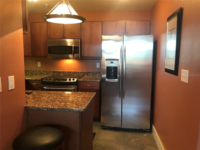 kitchen with decorative light fixtures, dark stone countertops, and stainless steel appliances